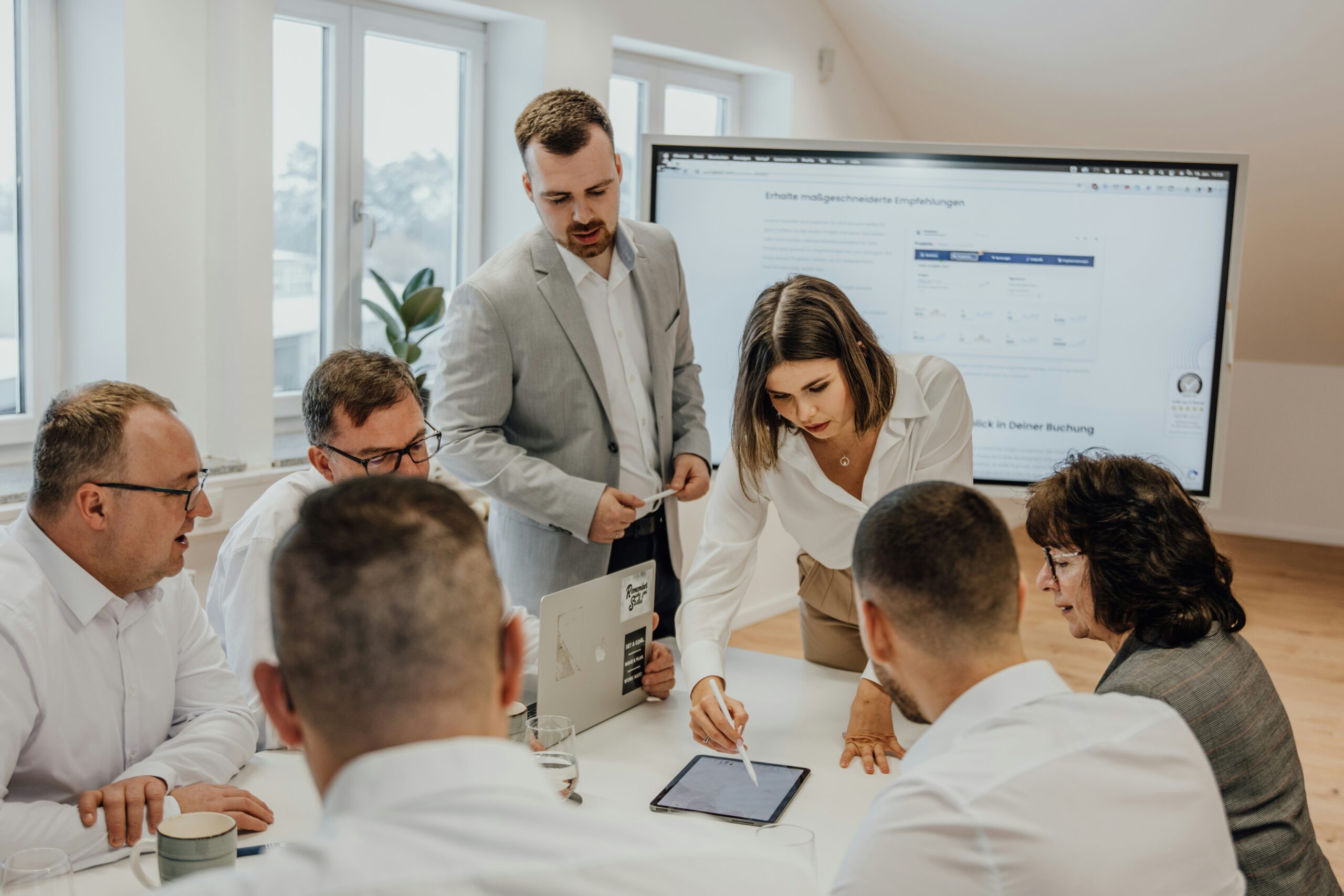 A high-performing sales team gathered around a table discussing data