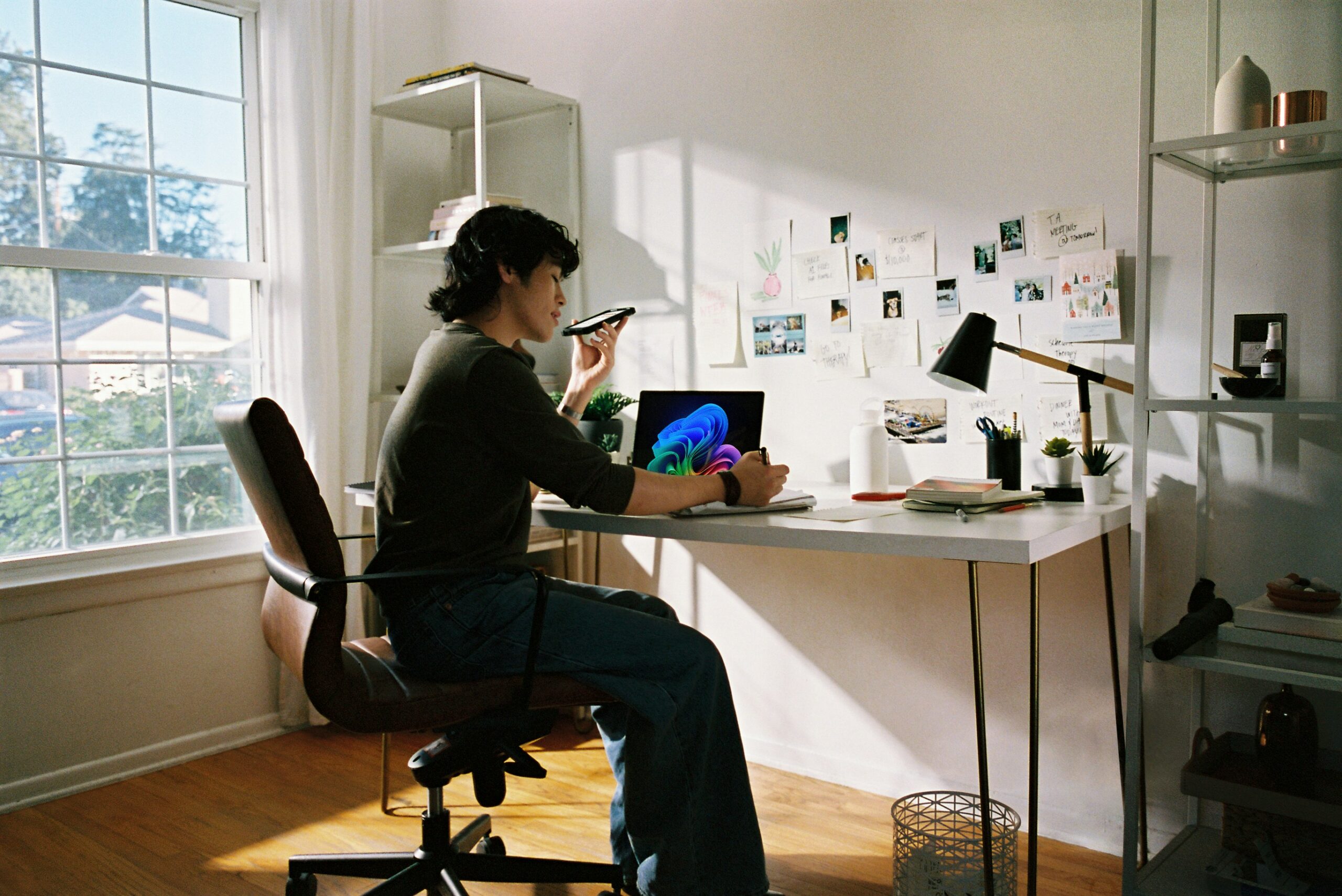Person working at a desk with laptop and a phone.